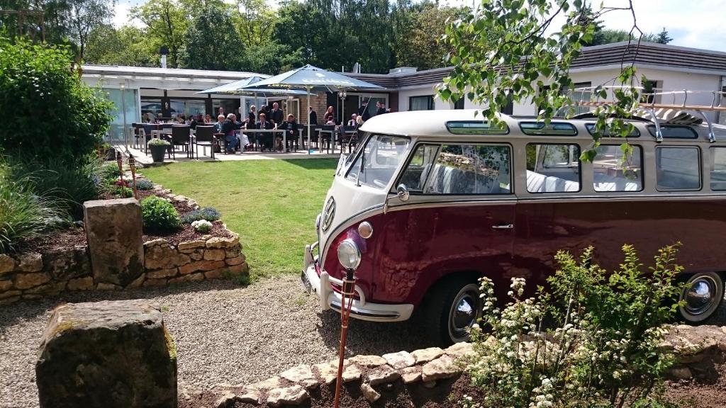 un vecchio furgone parcheggiato in un cortile accanto a un edificio. di Hotel Restaurant Margaretenhof a Überherrn