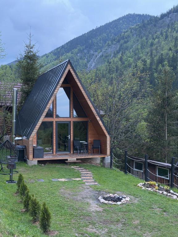 a large wooden cabin with a large window at A Way To Nature in Măgura