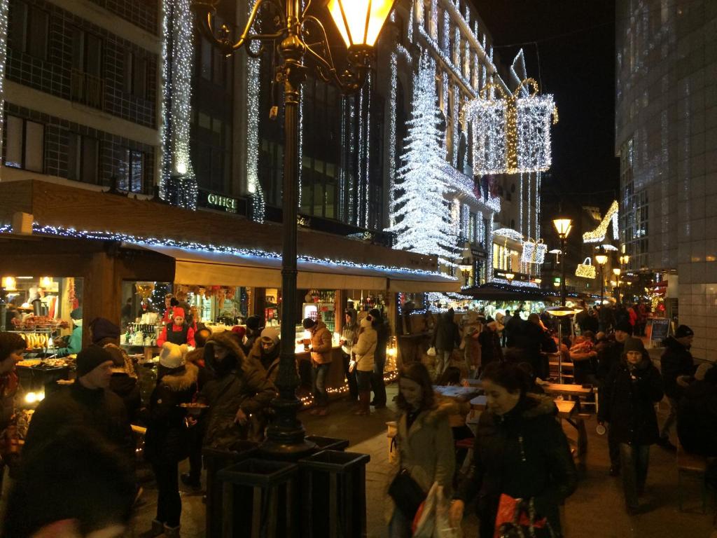 een menigte mensen die 's nachts op een markt rondlopen bij Deák design apartment in Boedapest