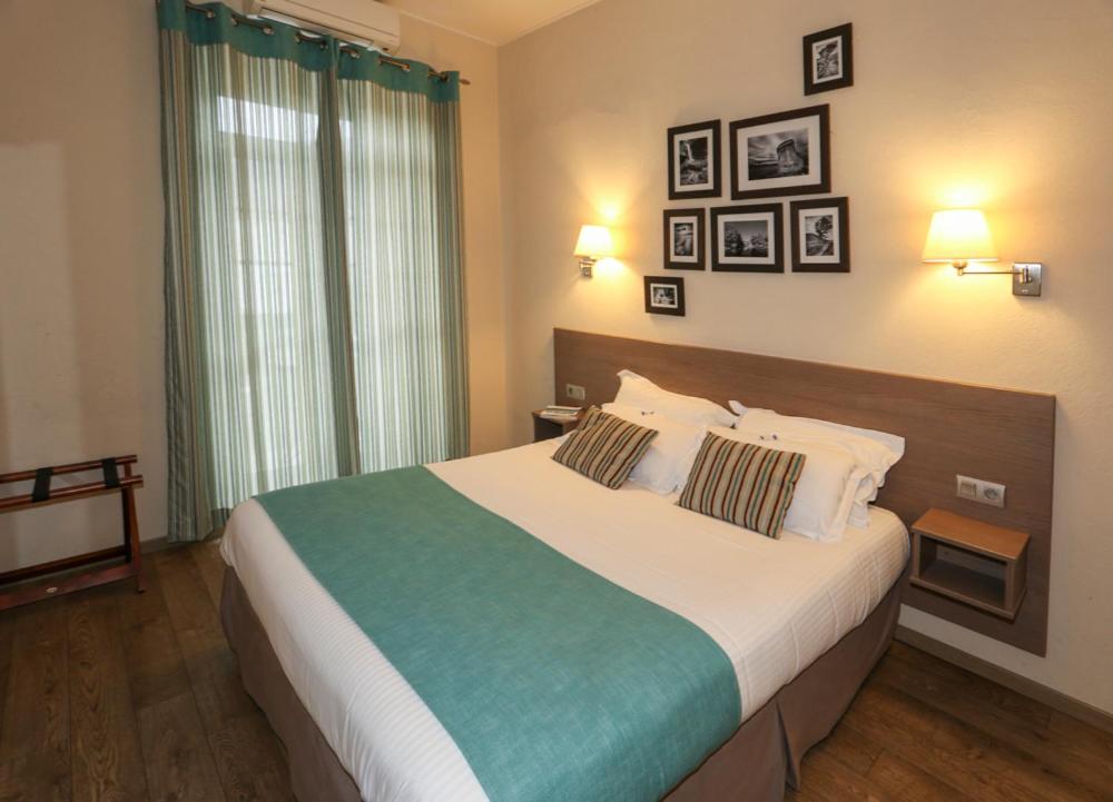 1 dormitorio con 1 cama grande y 2 almohadas en Hôtel Duc De Padoue, en Corte