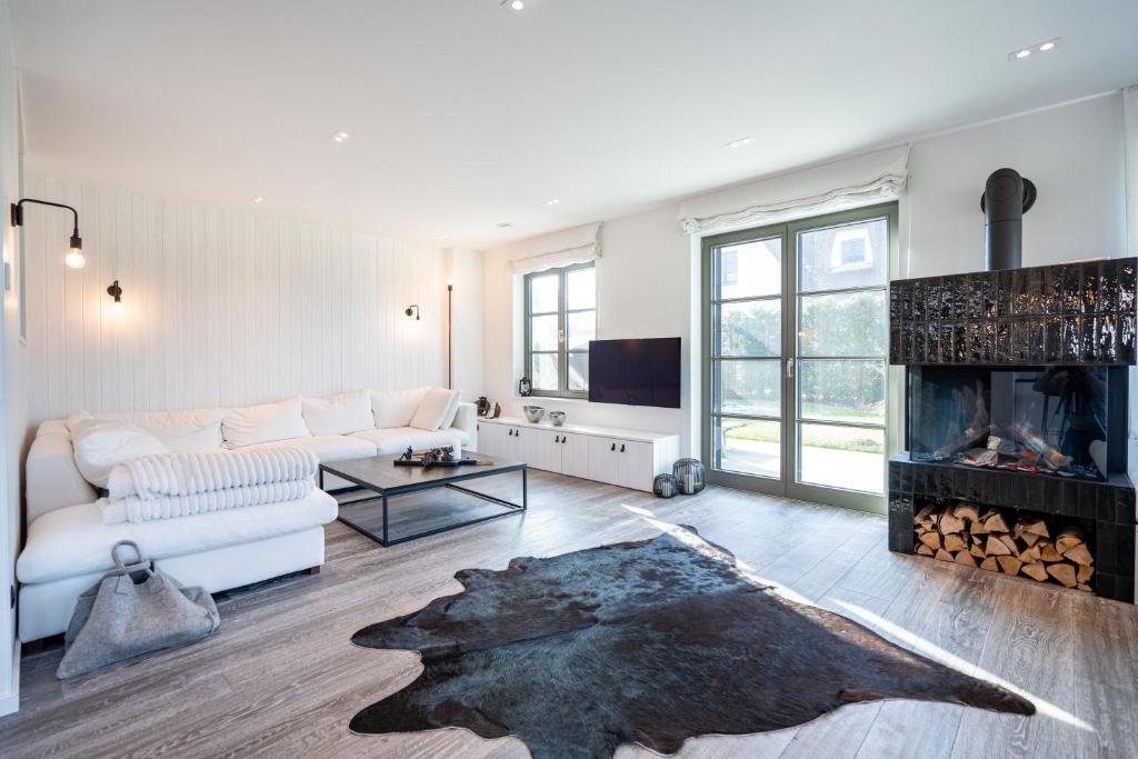 a living room with a couch and a fireplace at Reetidyll am Haff - Haus 2 in Stolpe auf Usedom