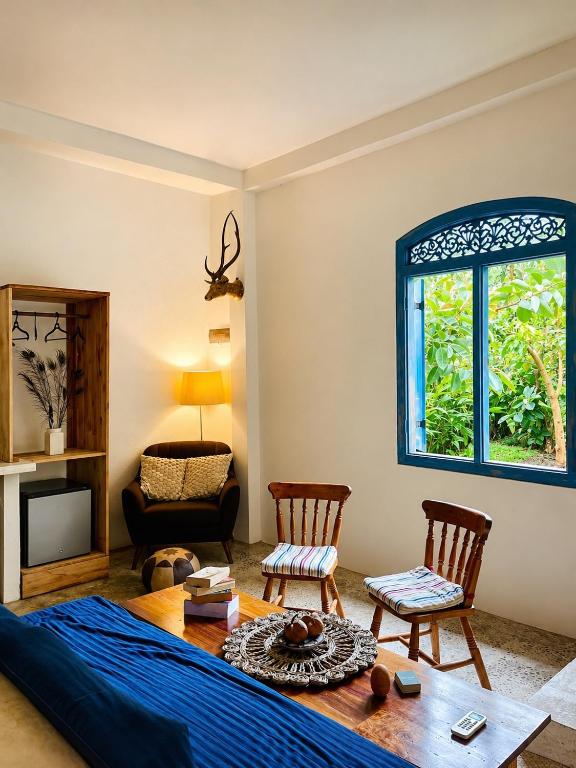 a bedroom with a bed and a table and chairs at Baker's cottage in Kosgoda