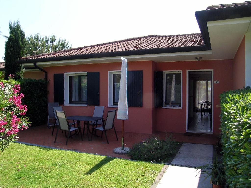 a house with a table and chairs and an umbrella at Corallo in Caleri
