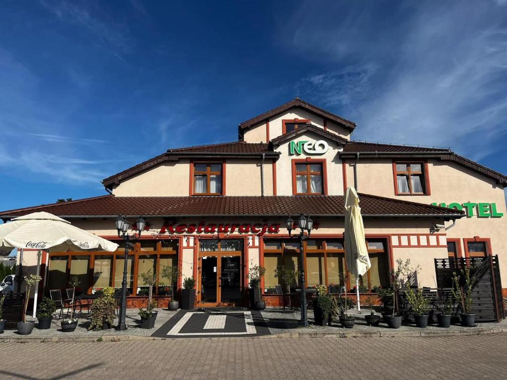 a building with an umbrella in front of it at Hotel Neo Międzyrzecz in Międzyrzecz