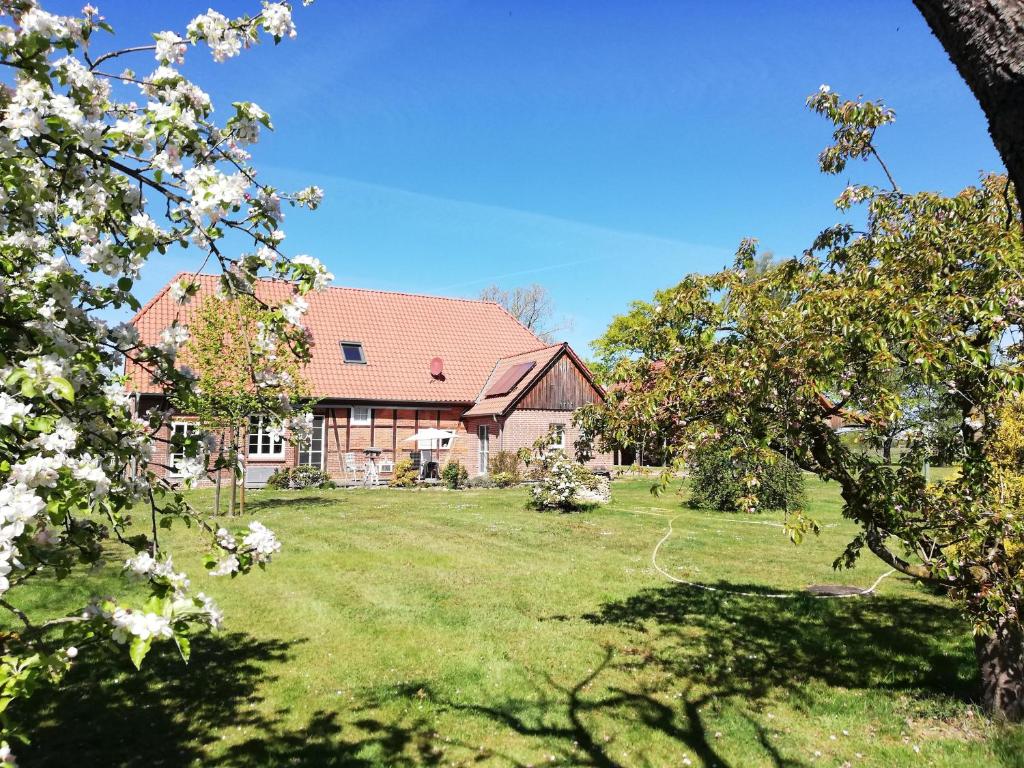 a house with a yard with trees in front of it at Ferienwohnung Landidyll Heese in Langlingen