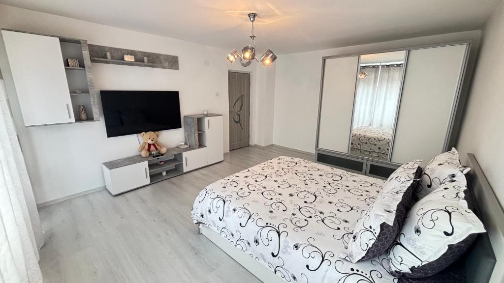 a bedroom with a bed and a flat screen tv at Apartament Ultra-Central Rm Valcea in Râmnicu Vâlcea