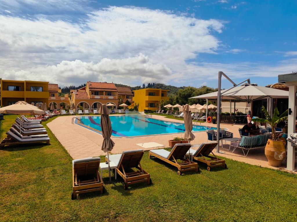 a swimming pool with lounge chairs and a poolvisorvisor at Tondoris Apartments in Sidari