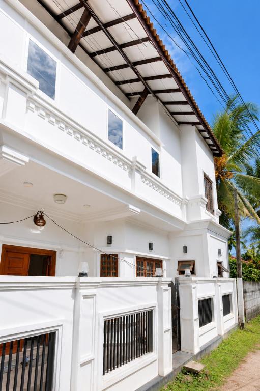 a white house with a fence in front of it at Princess Rose Villa in Vavuniya