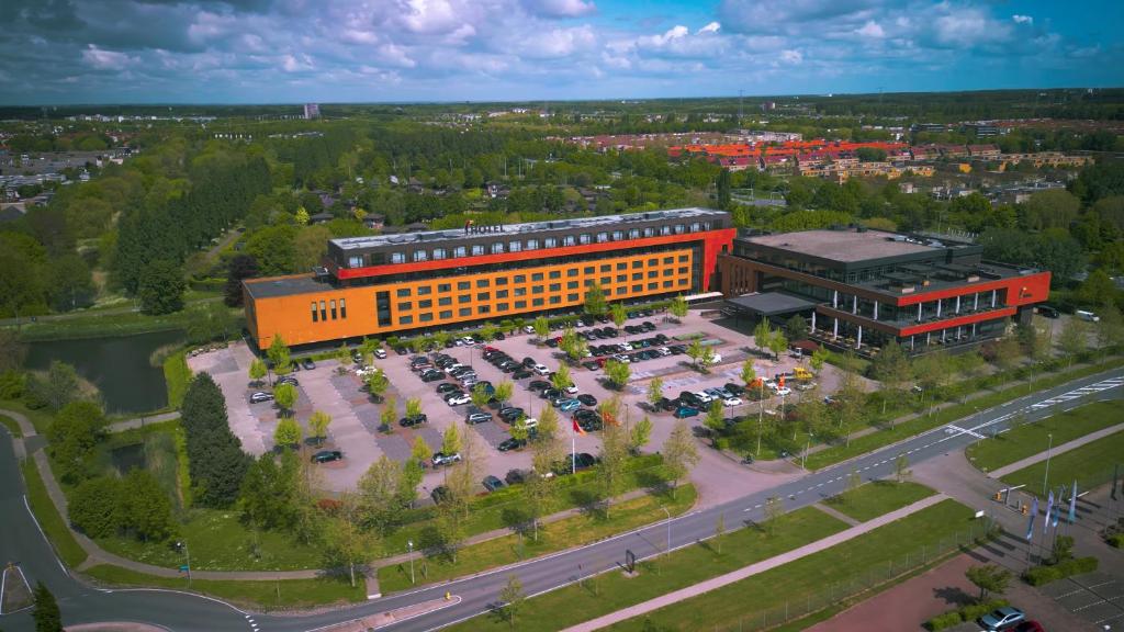 an overhead view of a large orange building with a parking lot at Van Der Valk Hotel Almere in Almere