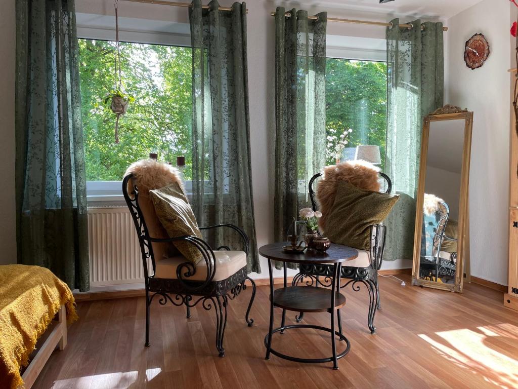 a bedroom with a table and two chairs and a window at Dorfstübli - gemütliche und ruhige Zimmer in Ortsrandlage in Alt Schönau