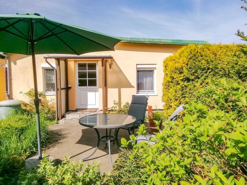 a patio with a table and a green umbrella at Ferienwohnungen Sirius in Zinnowitz