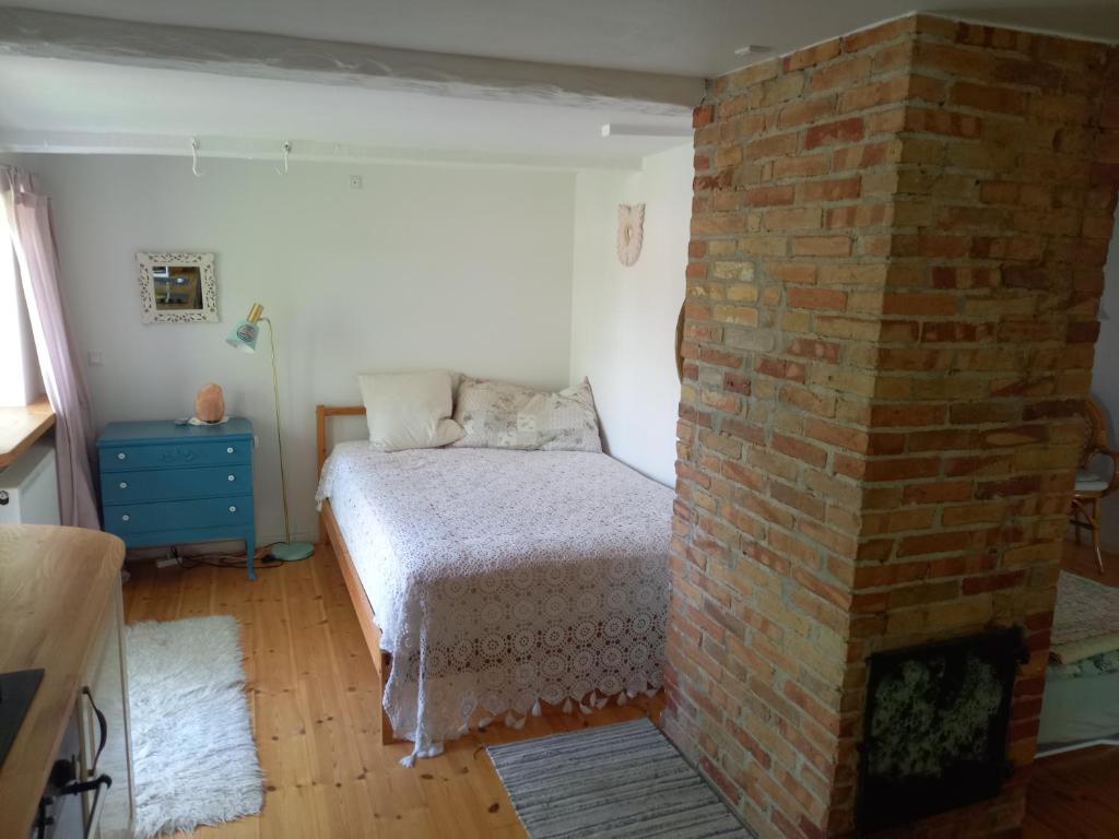 a bedroom with a brick wall next to a bed at Hasselsro in Tranekær