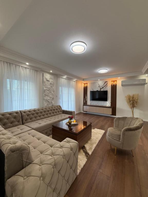 a living room with a sectional couch and a television at Apartman Lux Bileca in Bileća