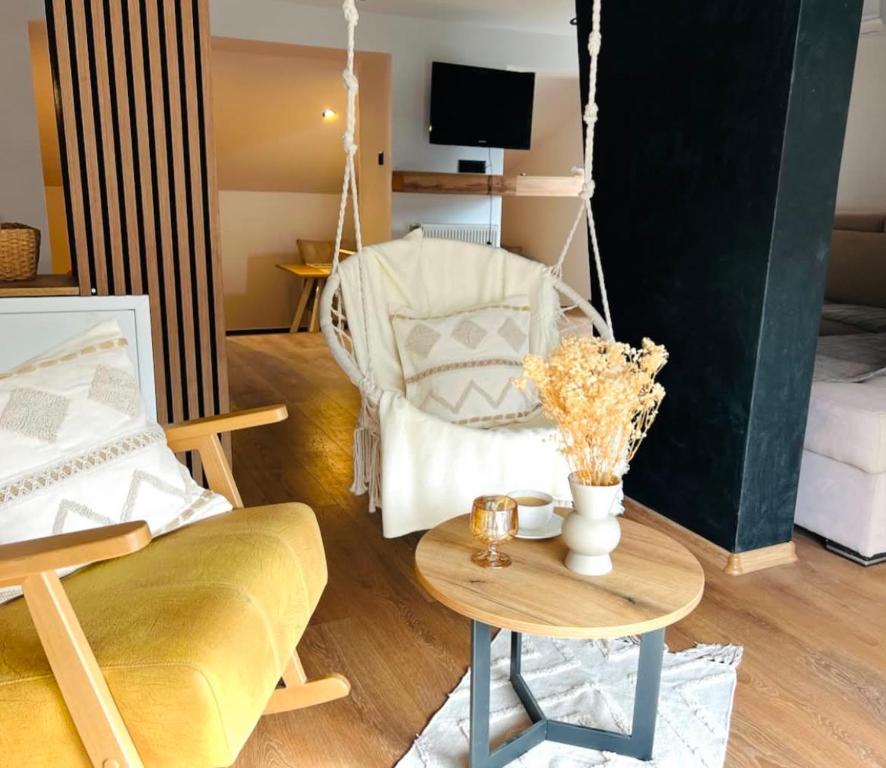 a living room with a swing chair and a table at Forest home in Konjic
