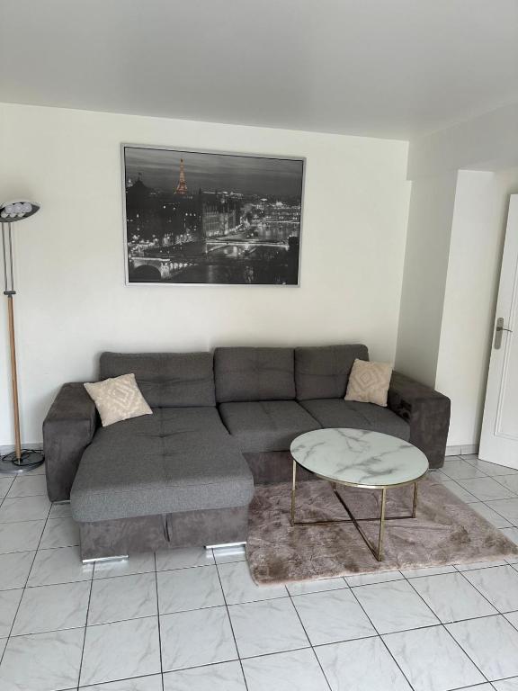 a living room with a couch and a table at appartement cosy tout équipe in Épinay-sur-Orge