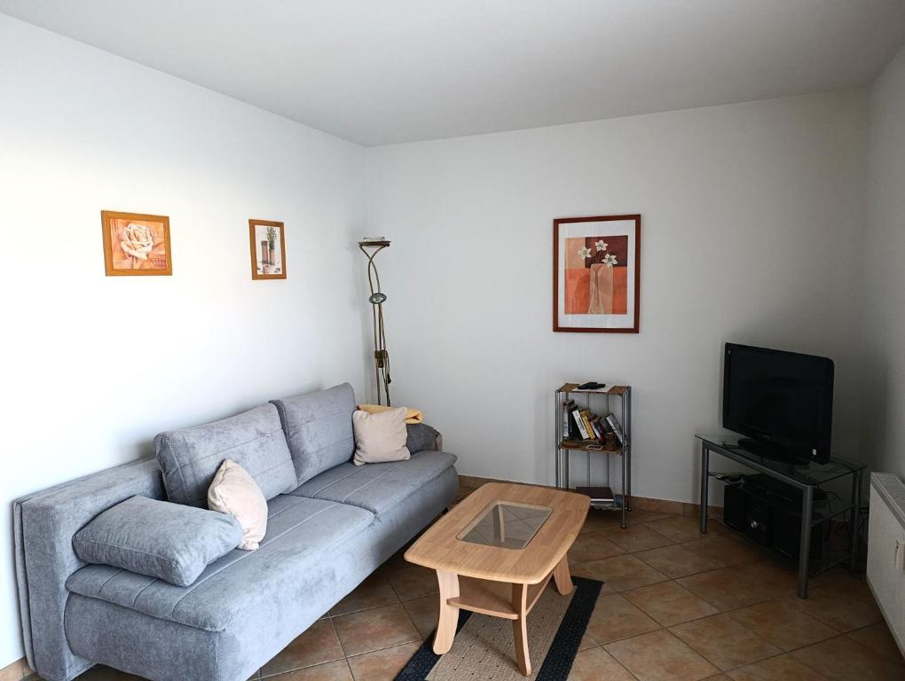 a living room with a couch and a tv at Residenz Strandkrone 09 in Kühlungsborn