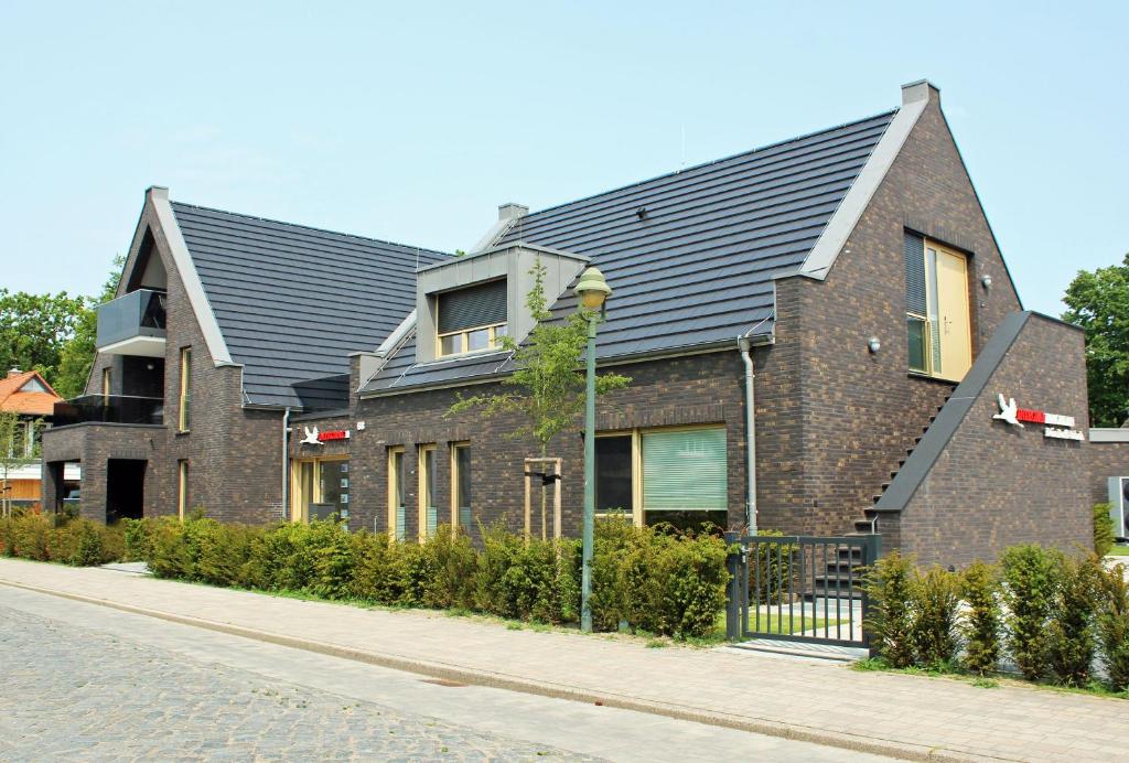 a house with a metal roof on a street at Ferienwohnung Boddenschnacker in Born