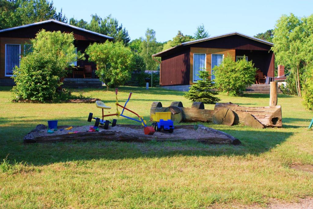 a toy playground in the grass in front of a house at Ferienhaus Stechlinsee 1 in Stechlin