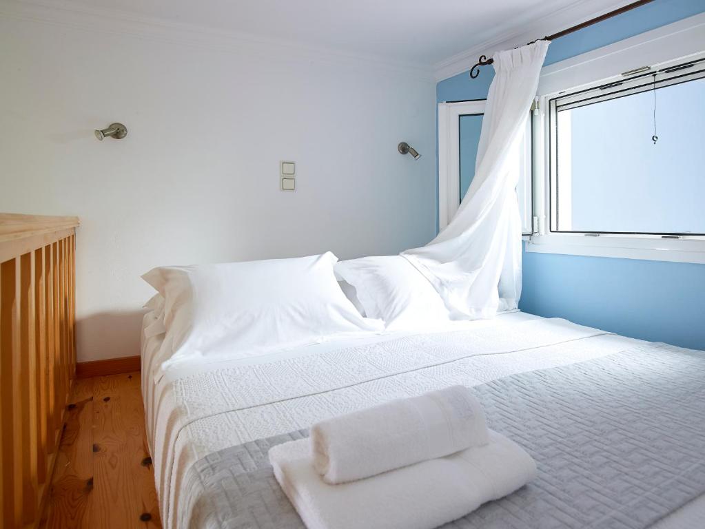 ポロニアにあるGarifalakis Houseのベッドルーム1室(窓、白いベッド1台付)