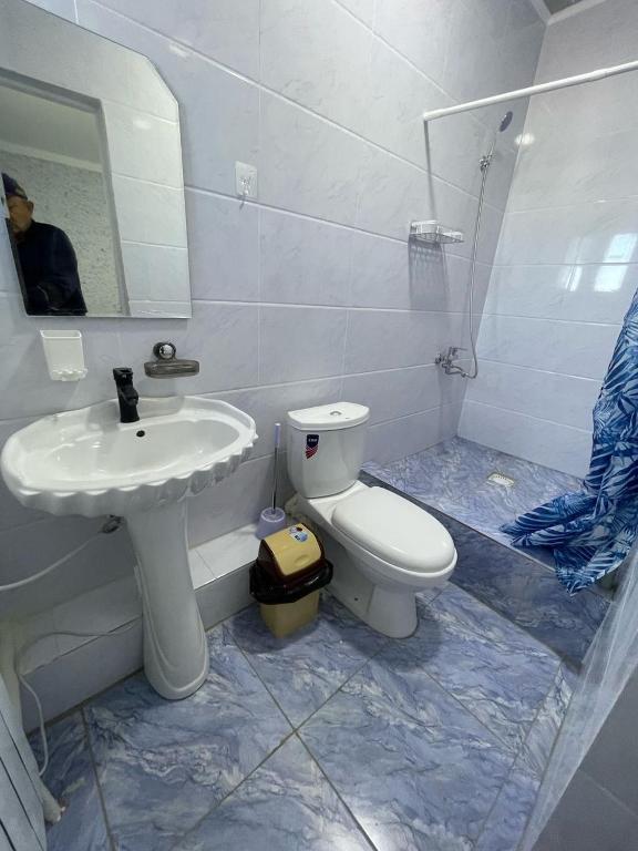a bathroom with a white toilet and a sink at Мотель Эмир in Pokrovka