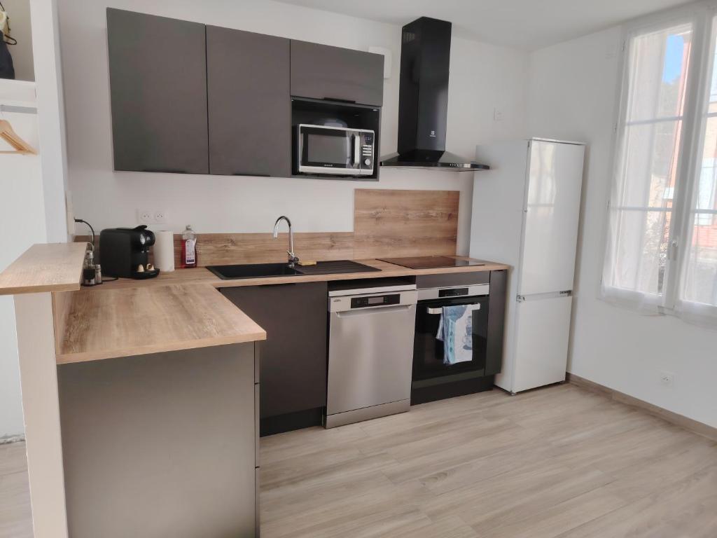 a kitchen with a sink and a stove and a refrigerator at Jauxvial 2 in Jaux
