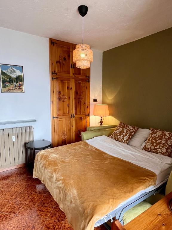 ein Schlafzimmer mit einem großen Bett und einer grünen Wand in der Unterkunft AlpNest in Saint Vincent
