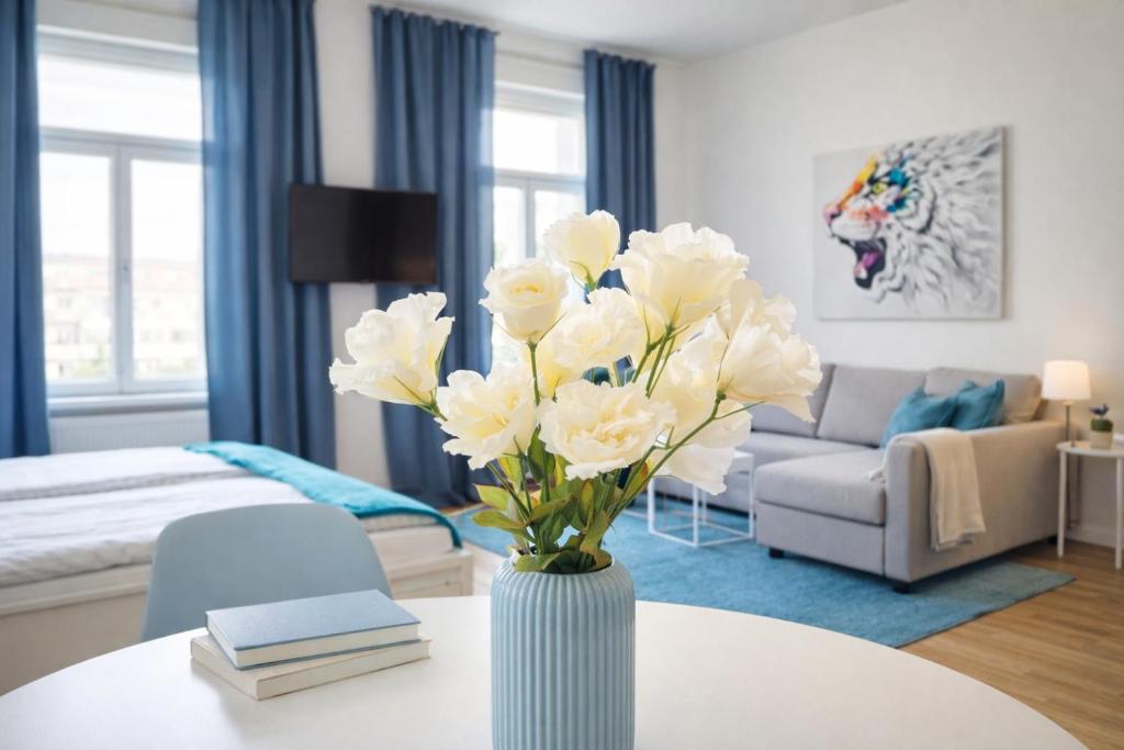 a vase with white flowers on a table in a living room at APSTAY City Residence Apartments ǀ Parking option & Self Check-in in Graz
