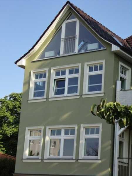 a green house with white windows on top of it at Ferienwohnung im Stadtpark in Neubrandenburg