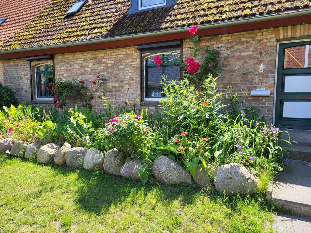 a garden in front of a house with flowers at Ferienhaus bei der Müritz-Elde Wasserstraße in Malchow