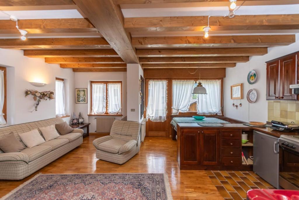 a kitchen and living room with a couch and a table at Ciase Ai Ronch in Falcade