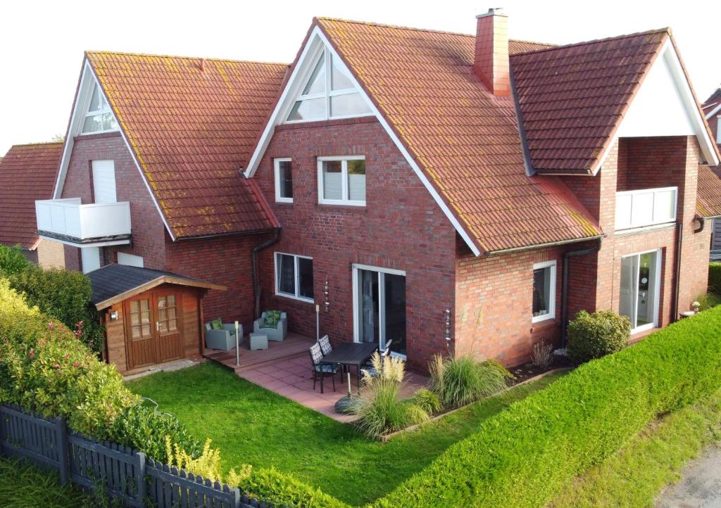 a large brick house with a patio in the yard at Deichwärts in Carolinensiel