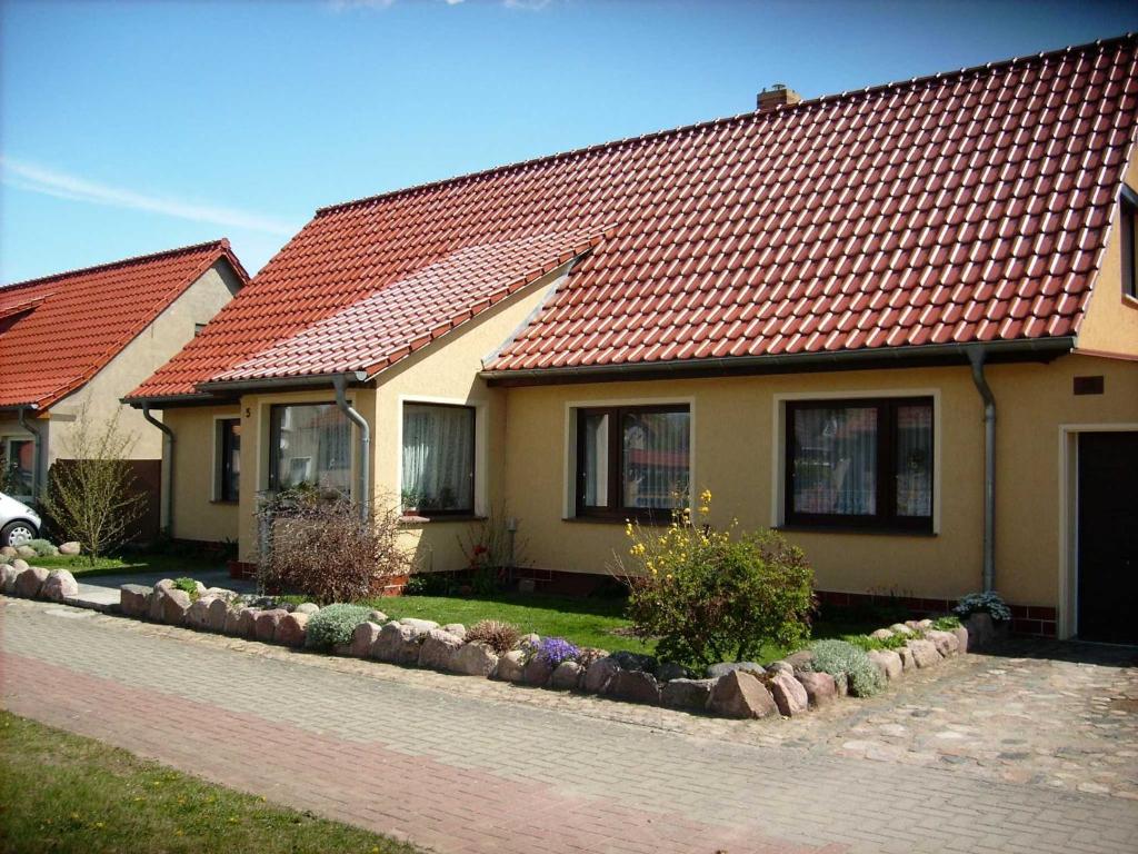 a house with a red roof on a street at Ferienwohnung "Ganz 1" in Vipperow