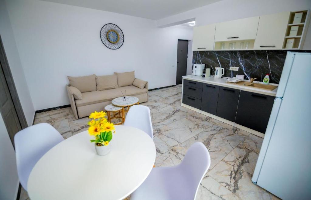a kitchen and a living room with a table and chairs at Nibiru Sea View in Costinesti