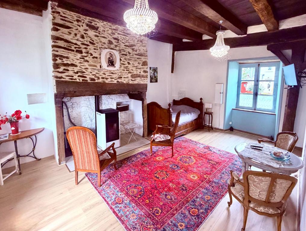 a living room with a fireplace and a table and chairs at La Maison d'Amélie à Arnac-Pompadour in Arnac-Pompadour
