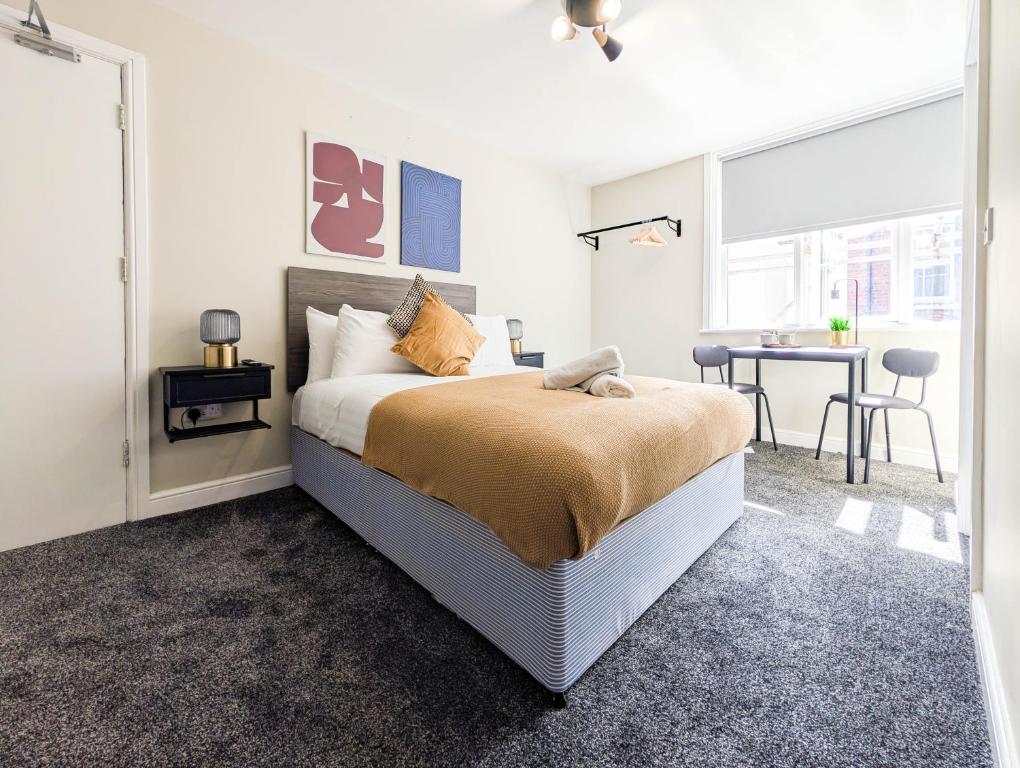 a bedroom with a bed and a desk and a table at The Marlowe in Southport