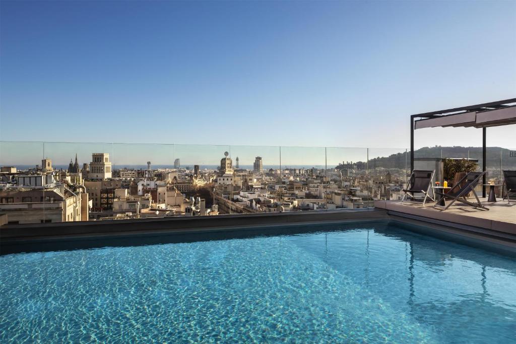 a swimming pool on top of a building with a view at NH Collection Barcelona Gran Hotel Calderon in Barcelona