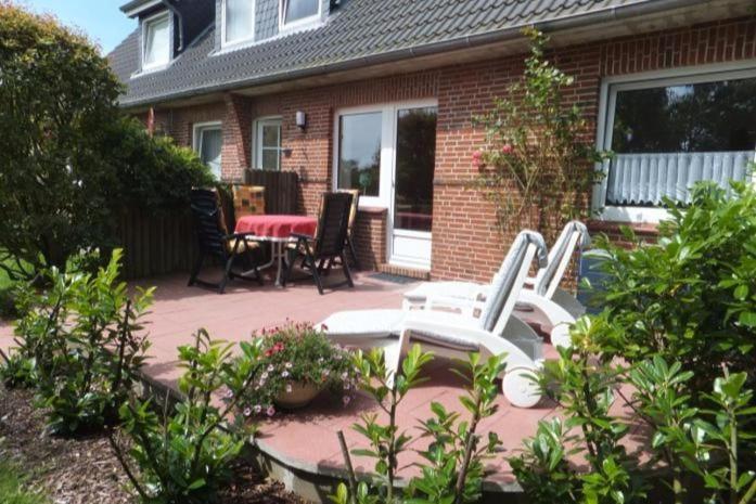 a patio with two chairs and a table in front of a house at Guatingwai 23 Jacobsen Whg 1 in Goting