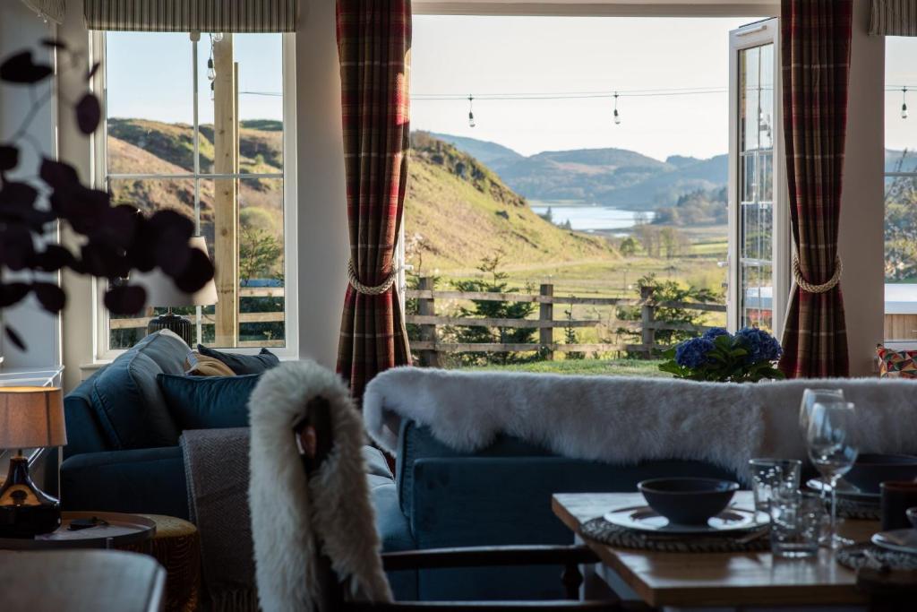 a living room with a couch and a large window at Penlarach House in Oban