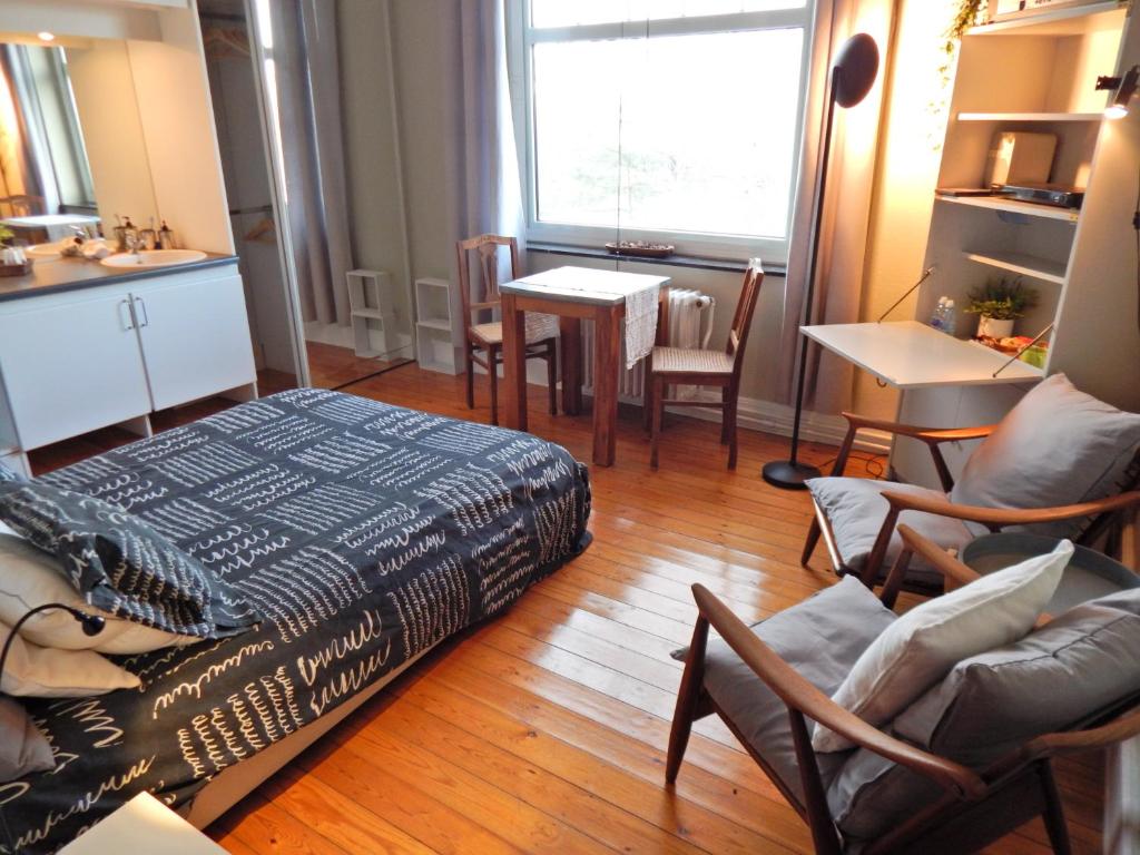 sala de estar con cama, mesa y sillas en Les Remparts en Binche