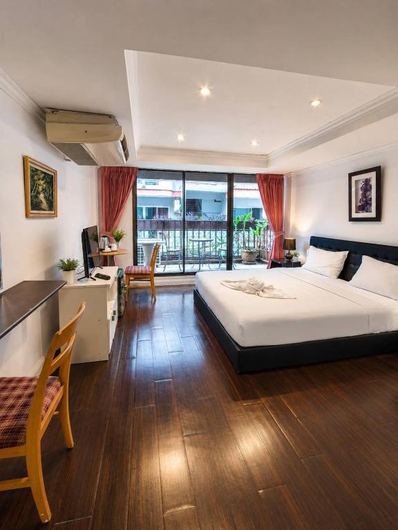 a bedroom with a large bed and a balcony at the L Hua Hin in Hua Hin