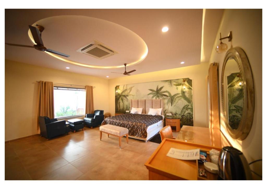 a bedroom with a bed and a living room with a desk at Dream Habitat Resort in Mohurli