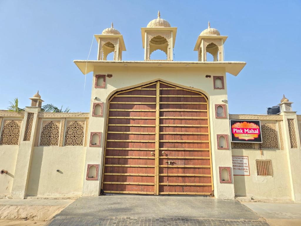 a building with a large wooden garage door at Pink Mahal Hotel & Resort in Jaipur