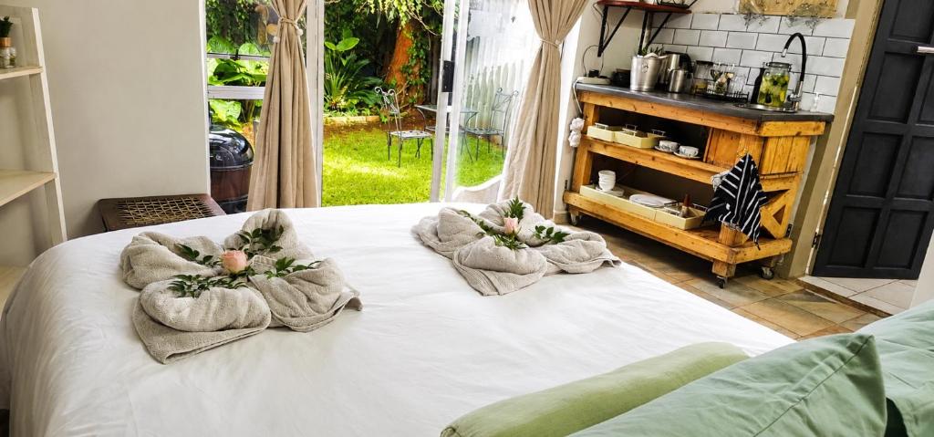 a bed with two towels on top of it at Rose cottage Garden Suite in Pretoria