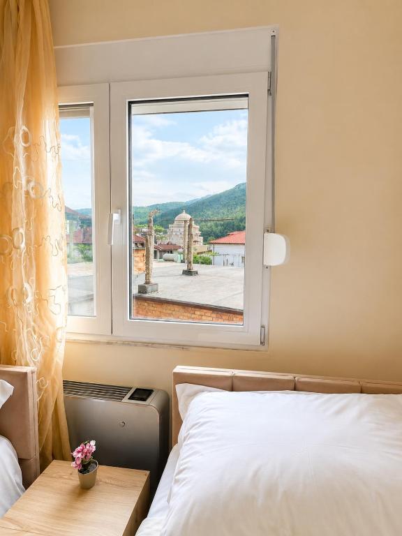 a bedroom with a bed and a window at R&A Apartments in Berat