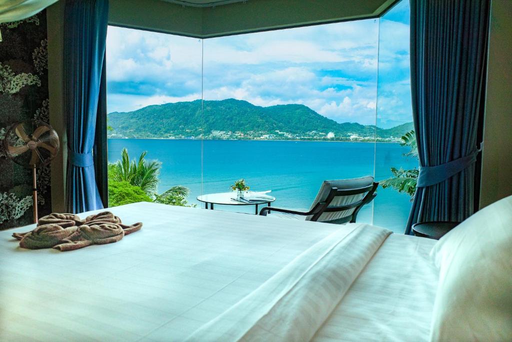 a bedroom with a bed and a view of the ocean at Salty Pearl Beach Front Phuket 3 in Patong Beach