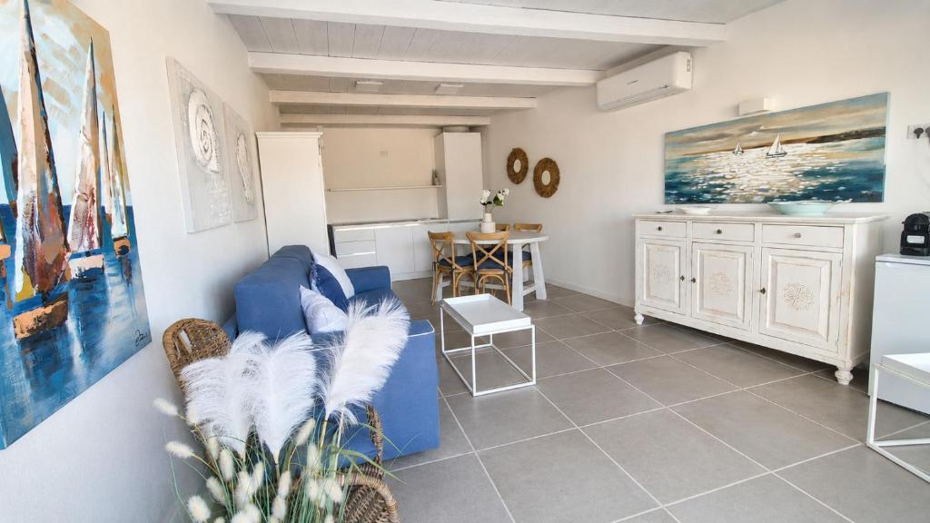 a living room with a blue couch and a kitchen at Rena Bianca Residence 241 in Arzachena