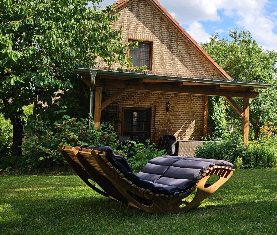 a swing chair sitting in the grass in front of a house at Ferienhaus Pathe in Neuendorf bei Wendisch Buchholz