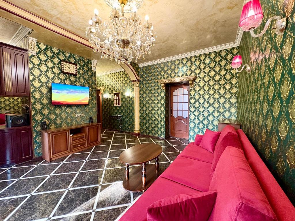 a living room with a pink couch and a chandelier at Aladdin apartment in Kharkiv