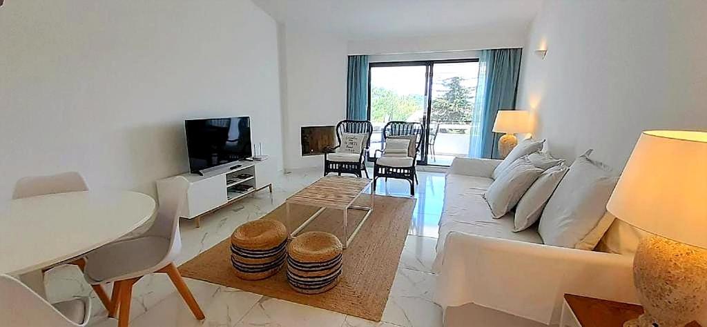 a living room with a couch and a table at Quinta do Lago Beach House in Quinta do Lago