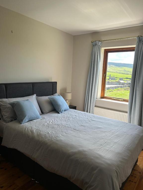 a bed with blue pillows in a bedroom with a window at Fanore Apartment 1 in Fanore